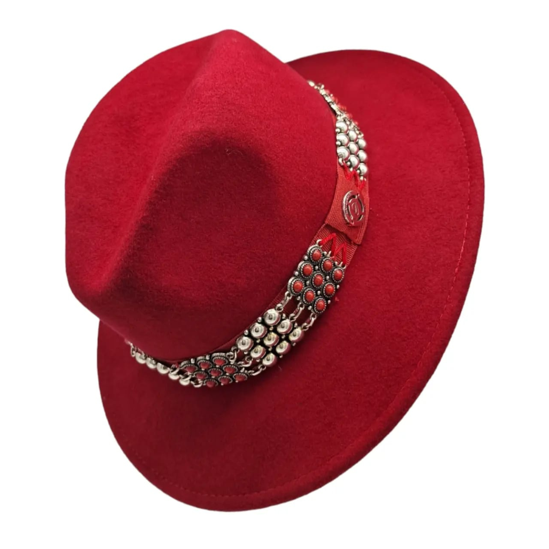 TANILA est un chapeau en laine rouge orné d’un bijou kabyle. Il est imperméabilisé et garni à l’intérieur d’un tissu soyeux.